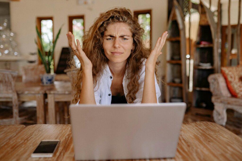 Eine Frau sitzt frustriert vor einem Laptop